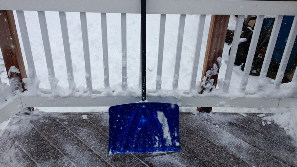 A snow shovel on a deck.